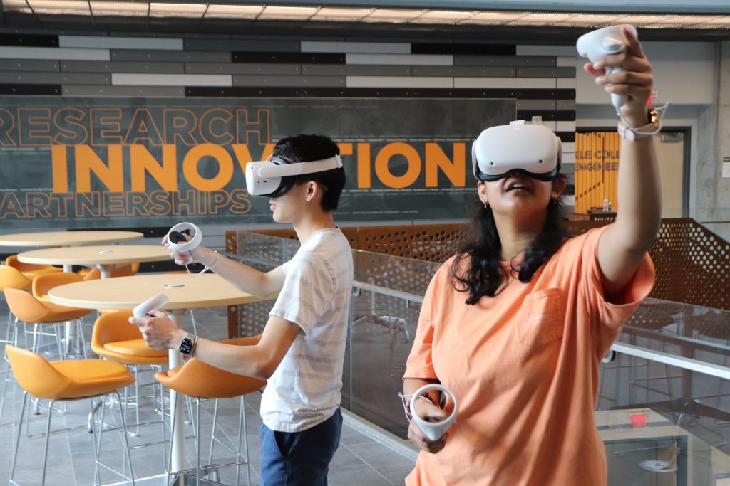 Picture of students wearing virtual reality headsets and holding VR controllers in their hands, in the Zeanah Engineering Complex atrium